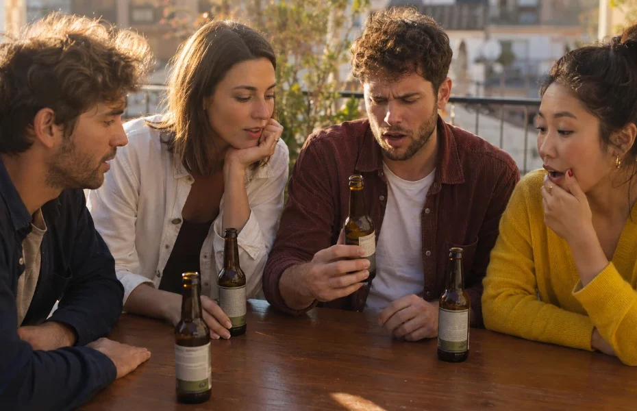 amis surpris par le goût d'une bière Jupiler en bouteille