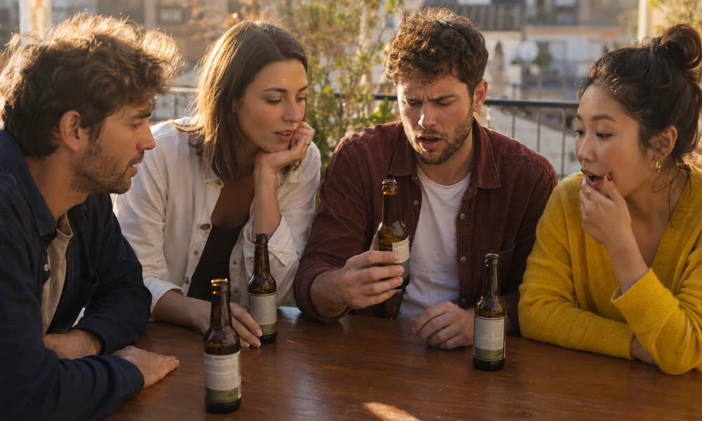amis surpris par le goût d'une bière Jupiler en bouteille
